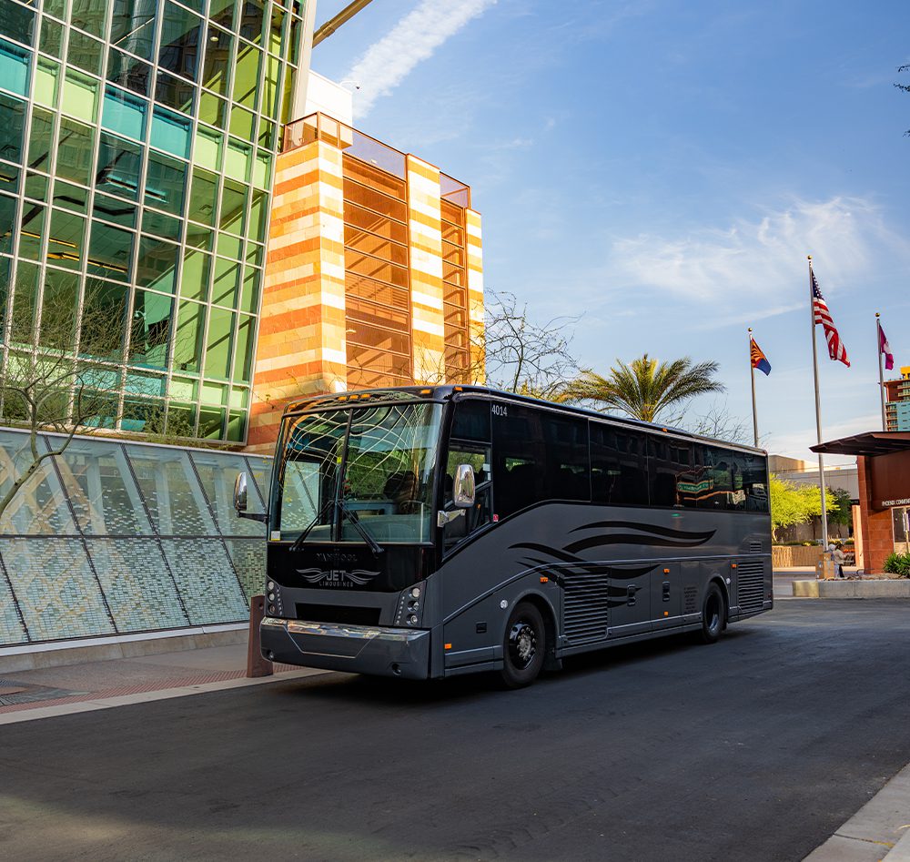 A black bus is driving down the street